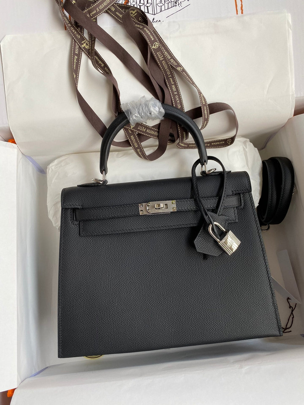 Black handbag with gold hardware on a white surface