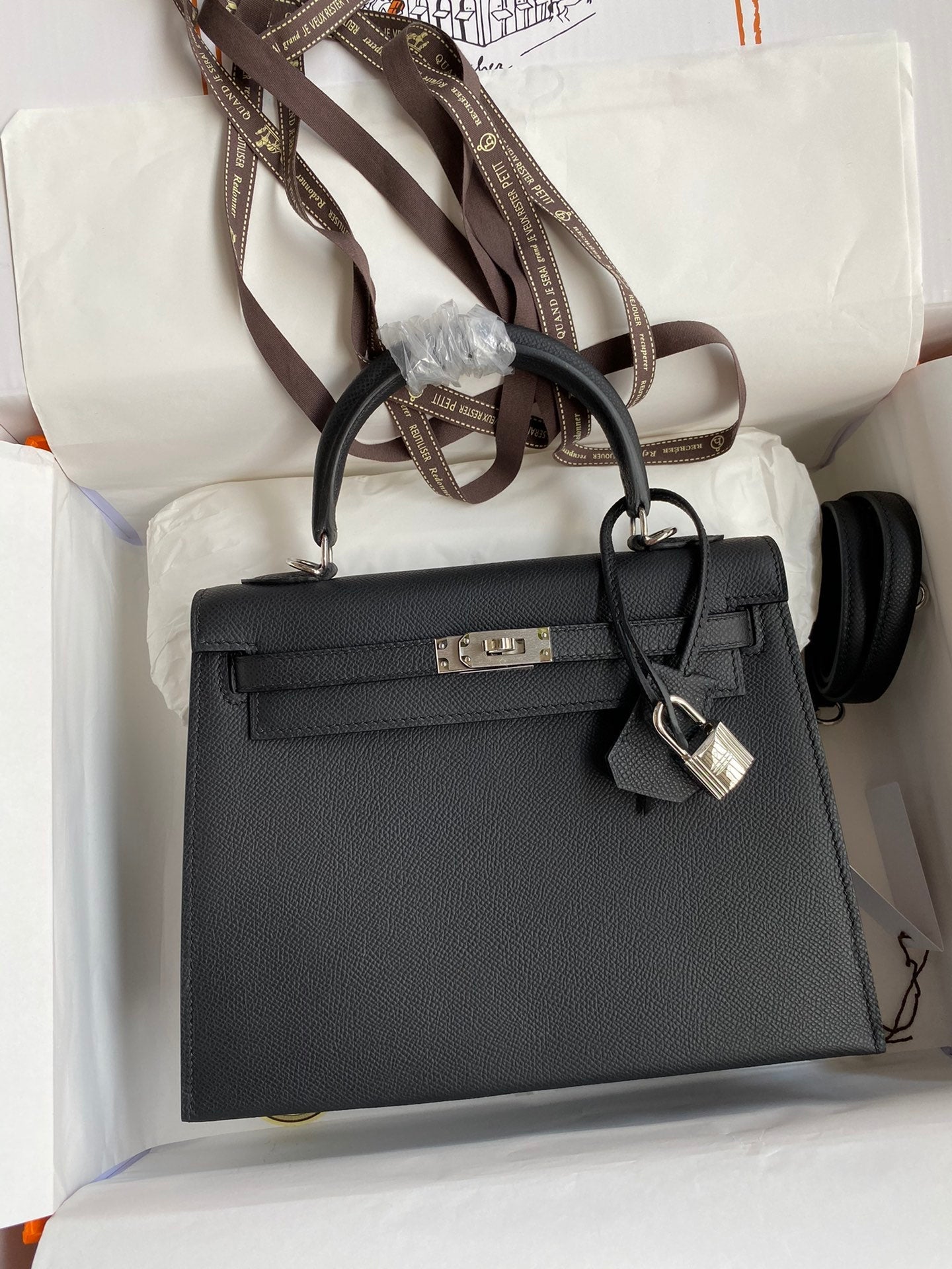 Black handbag with gold hardware on a white surface