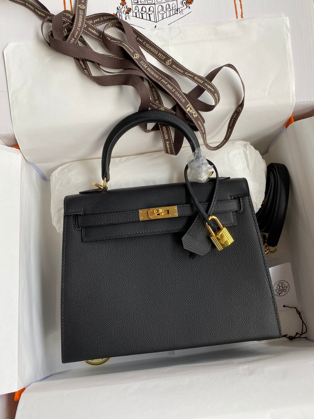 Black handbag with gold hardware on a white background