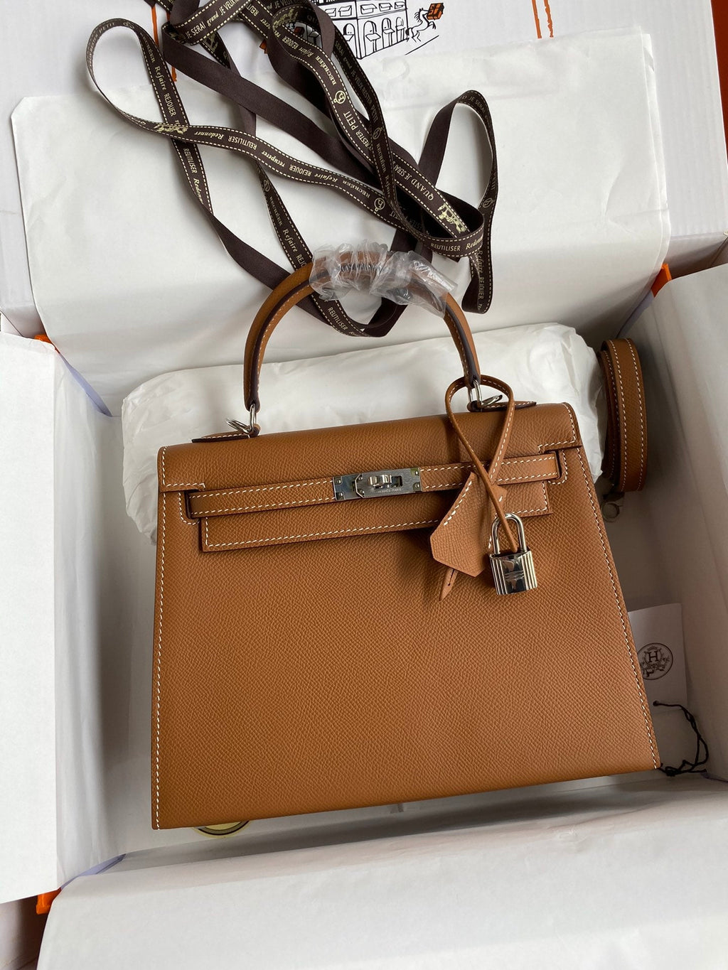 Brown handbag with gold hardware in a white box