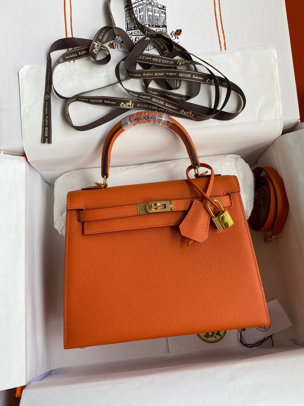 Orange handbag with gold hardware on a white background