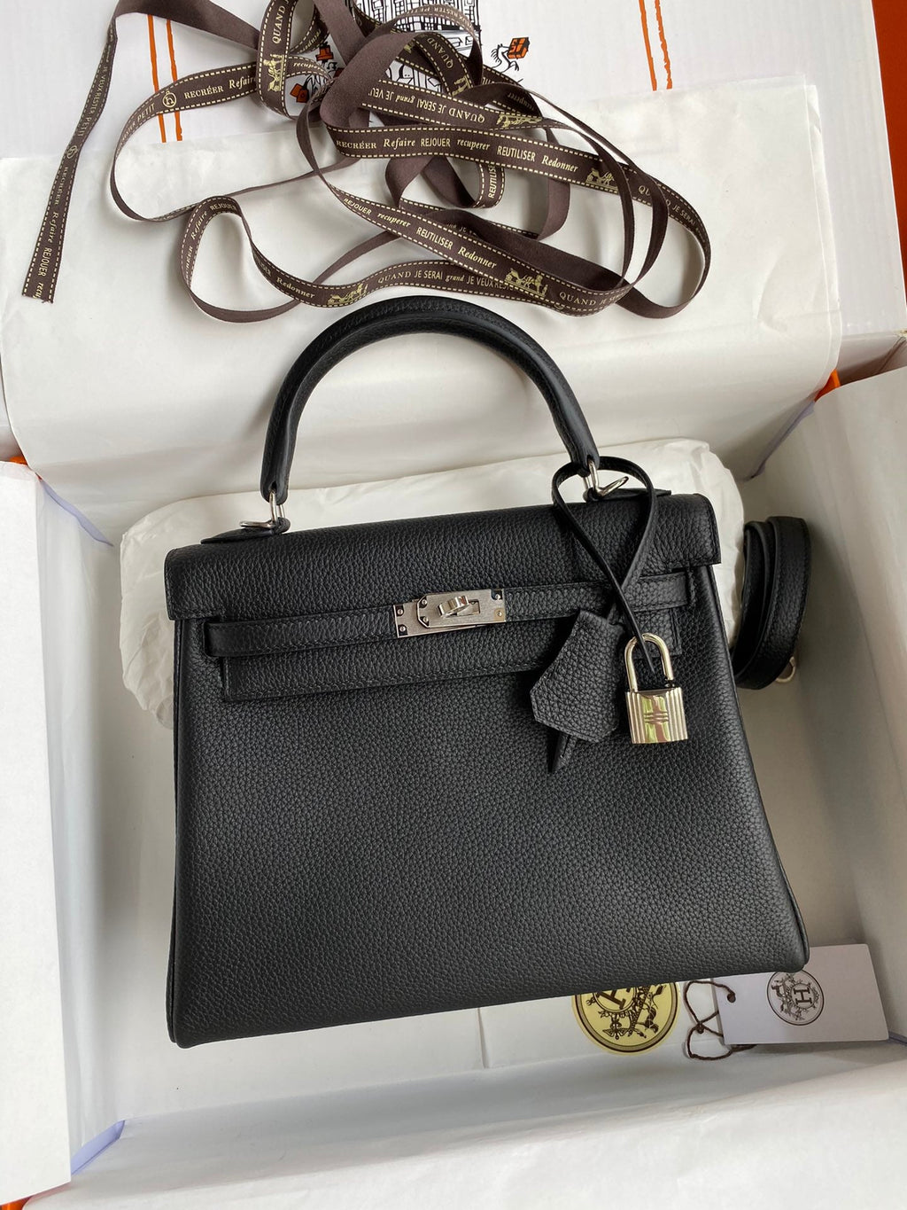 Black handbag with gold lock on a white background