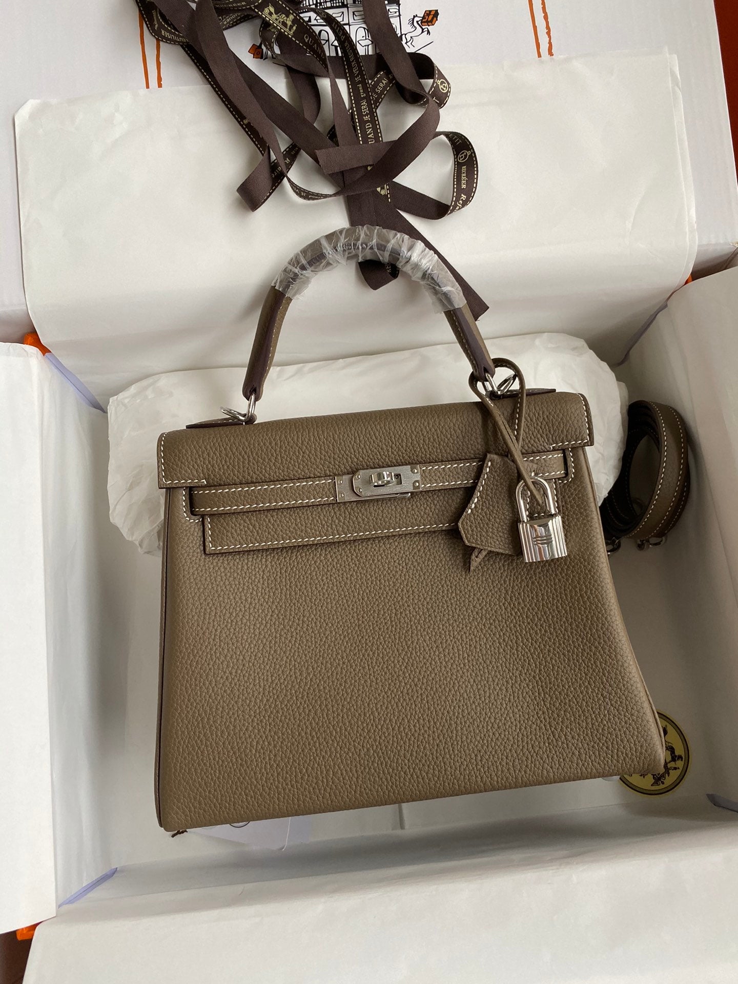 Brown handbag with silver hardware on a white background