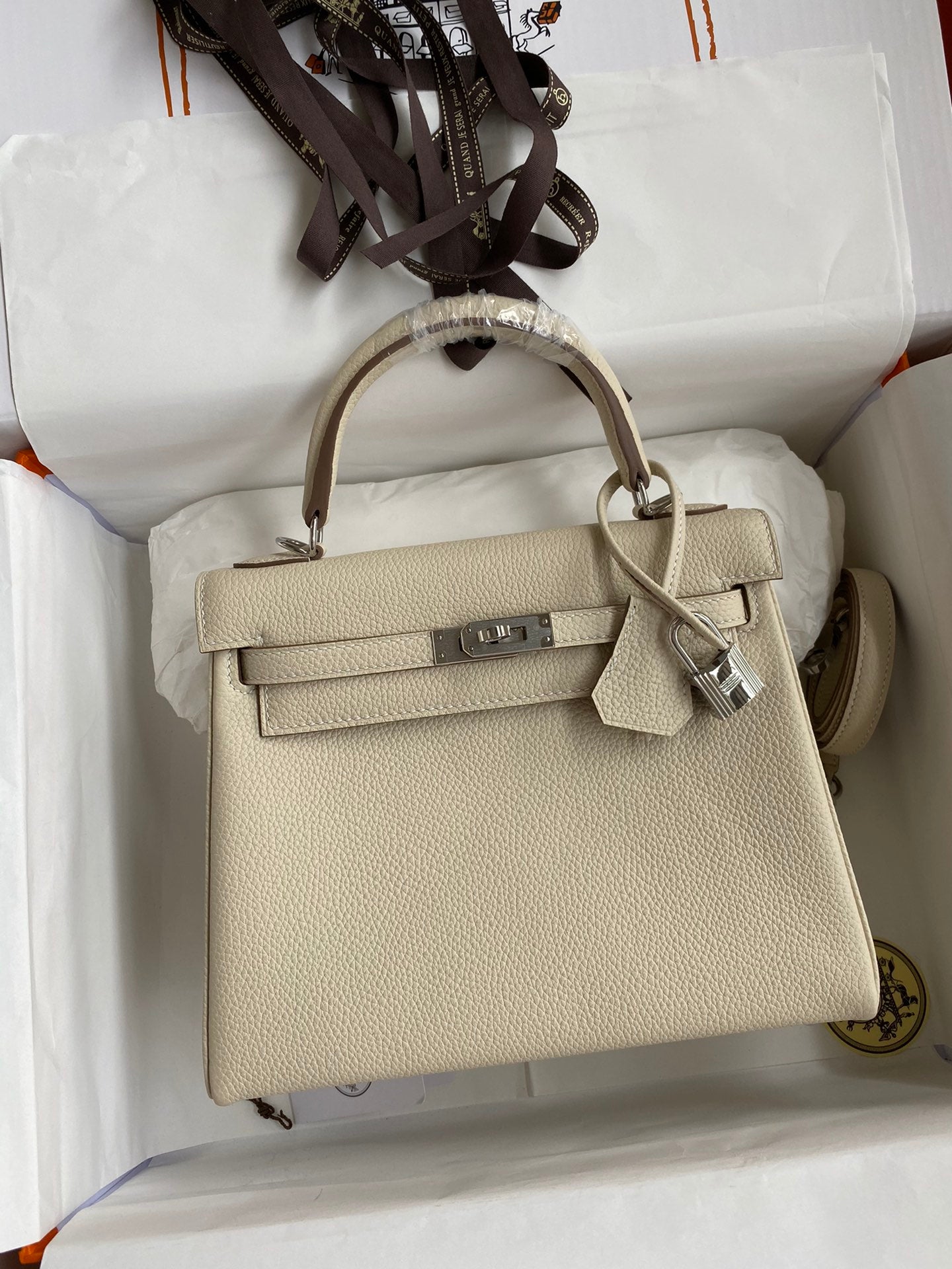 Beige handbag with silver hardware on a white background