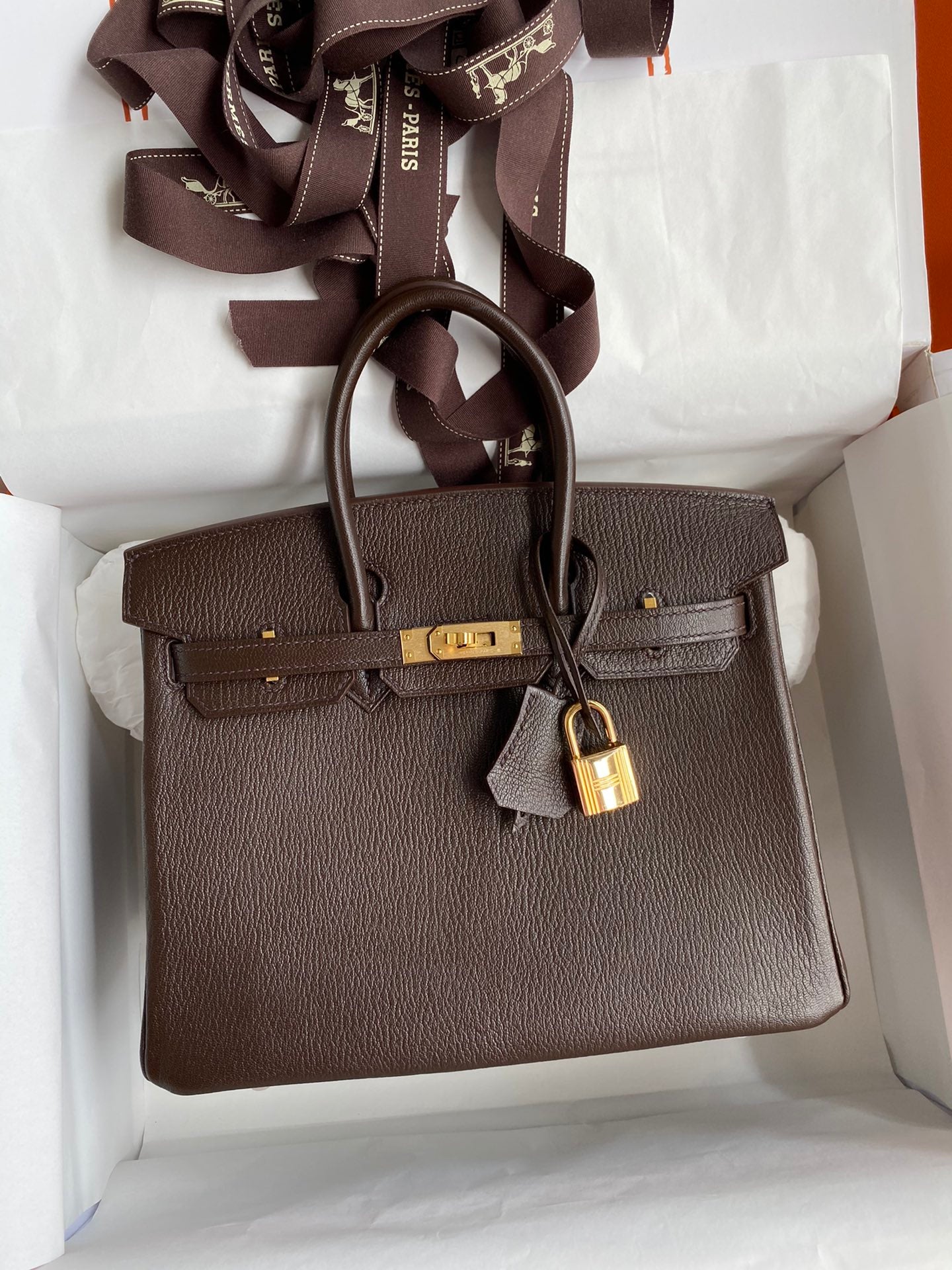 Brown handbag with gold lock in a box