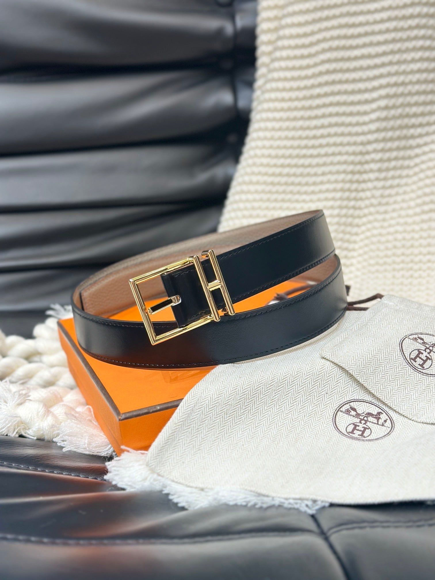 Black belt with gold buckle on an orange box, with a blurred background