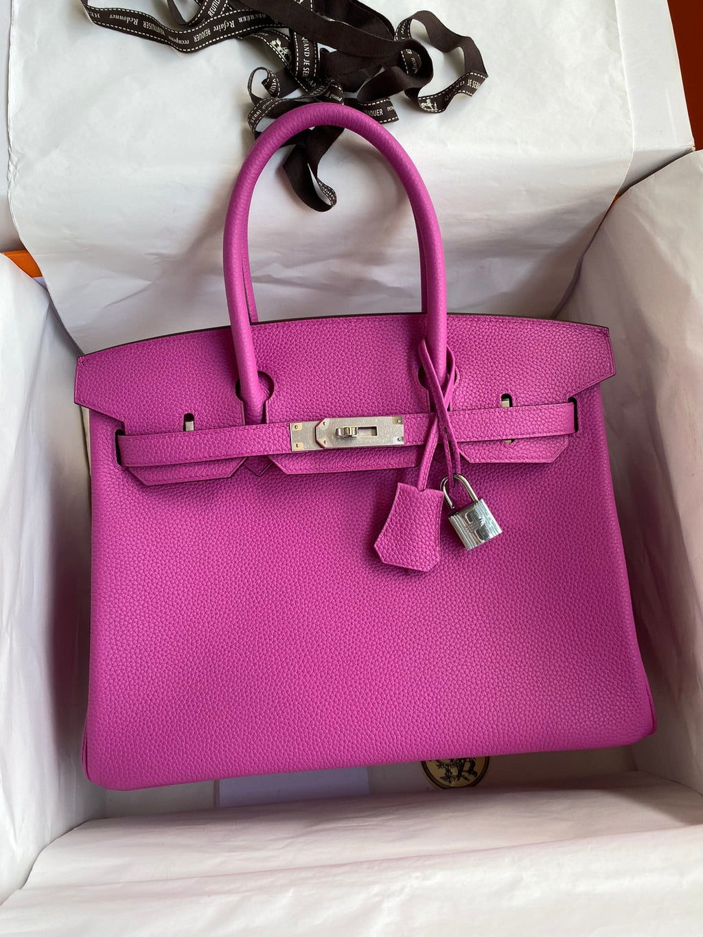 Pink handbag with silver hardware in a box