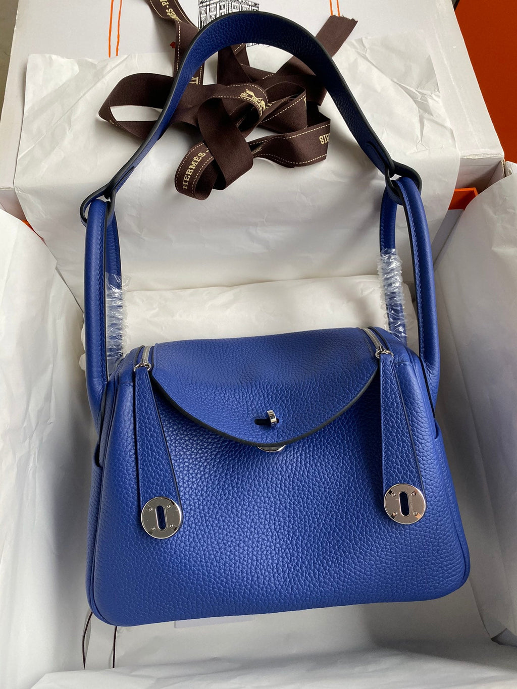 Blue handbag with silver hardware on a white background
