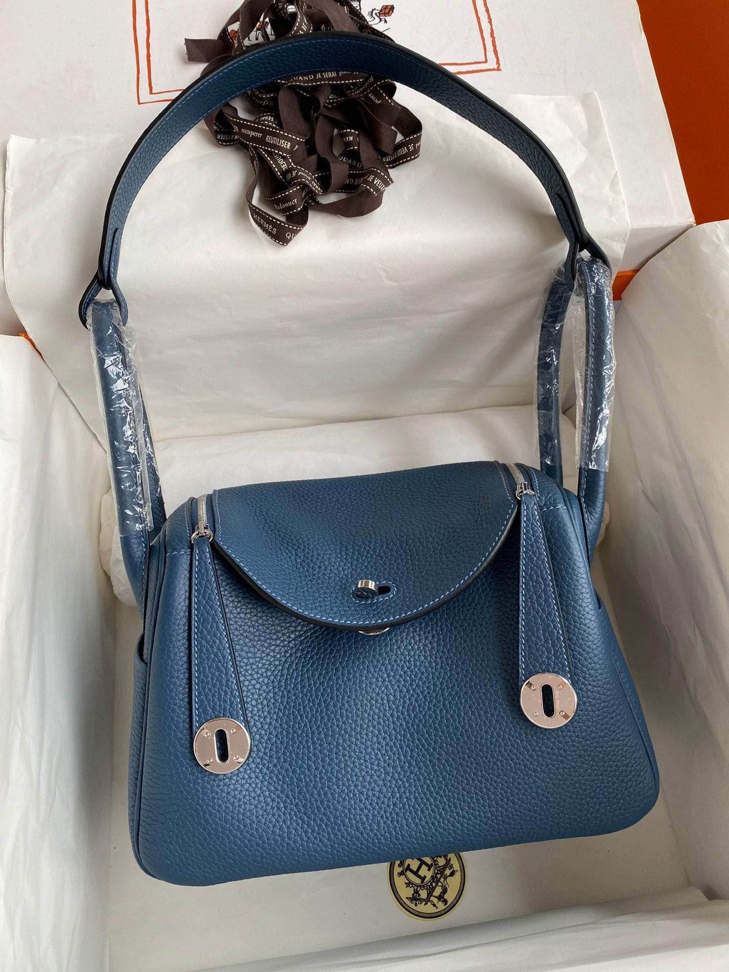 Blue handbag with a visible brand logo on a white background