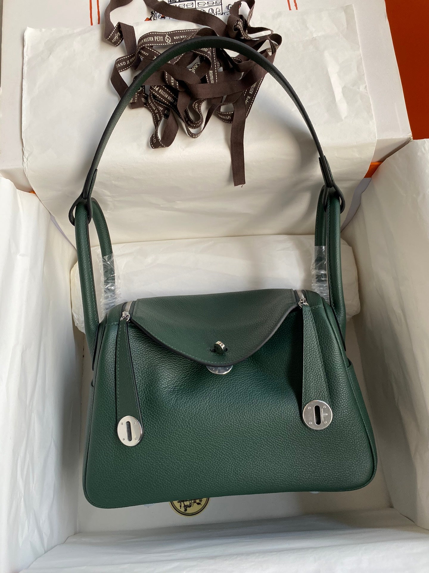 Green handbag with silver hardware on a white background