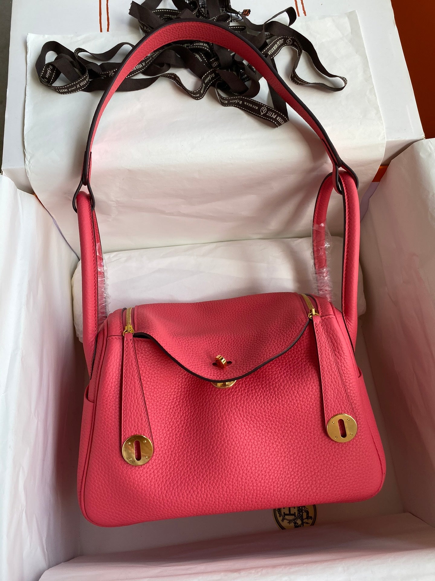 Red handbag with gold accents on a white surface