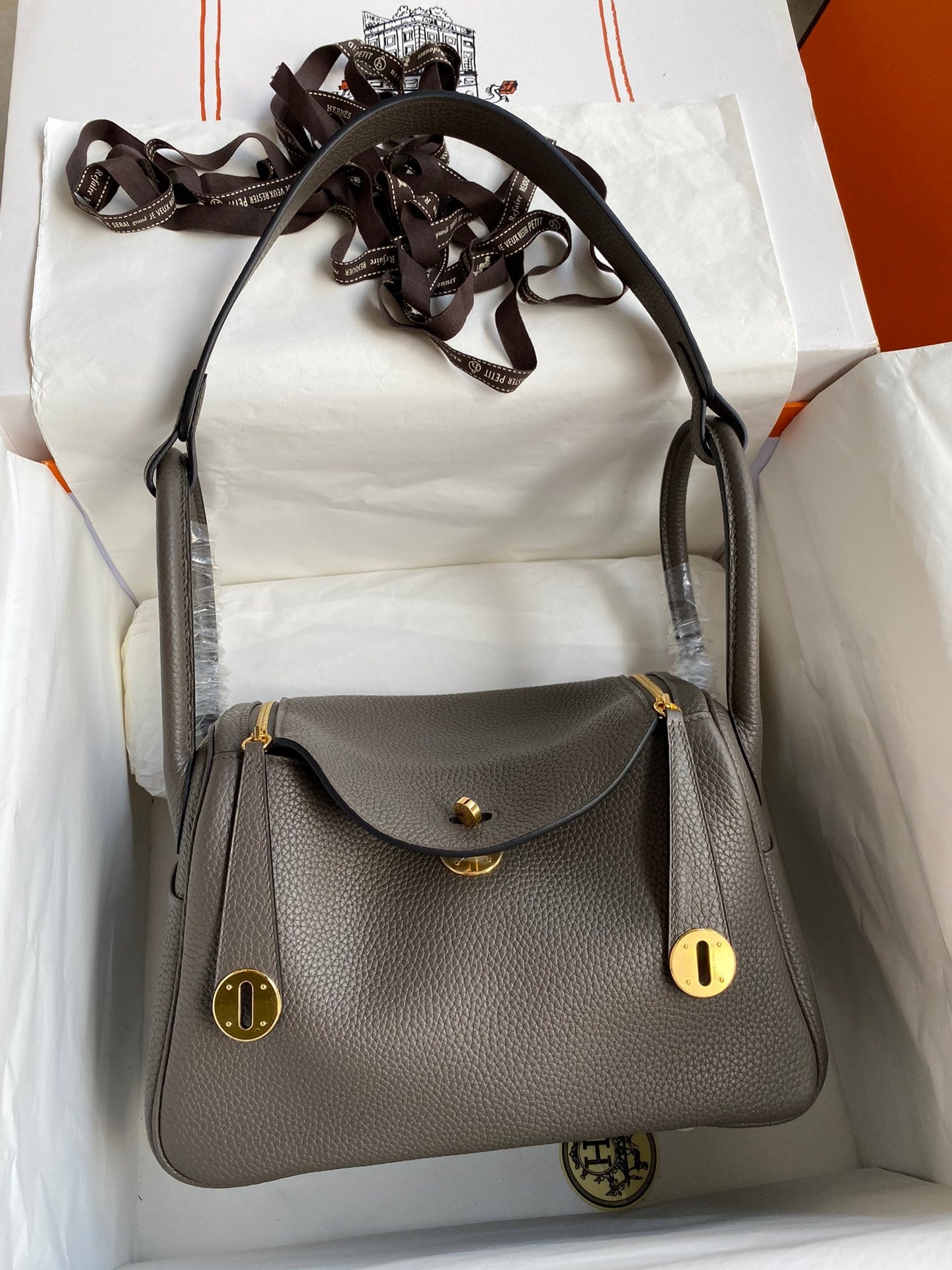 Gray handbag with gold accents on a white background