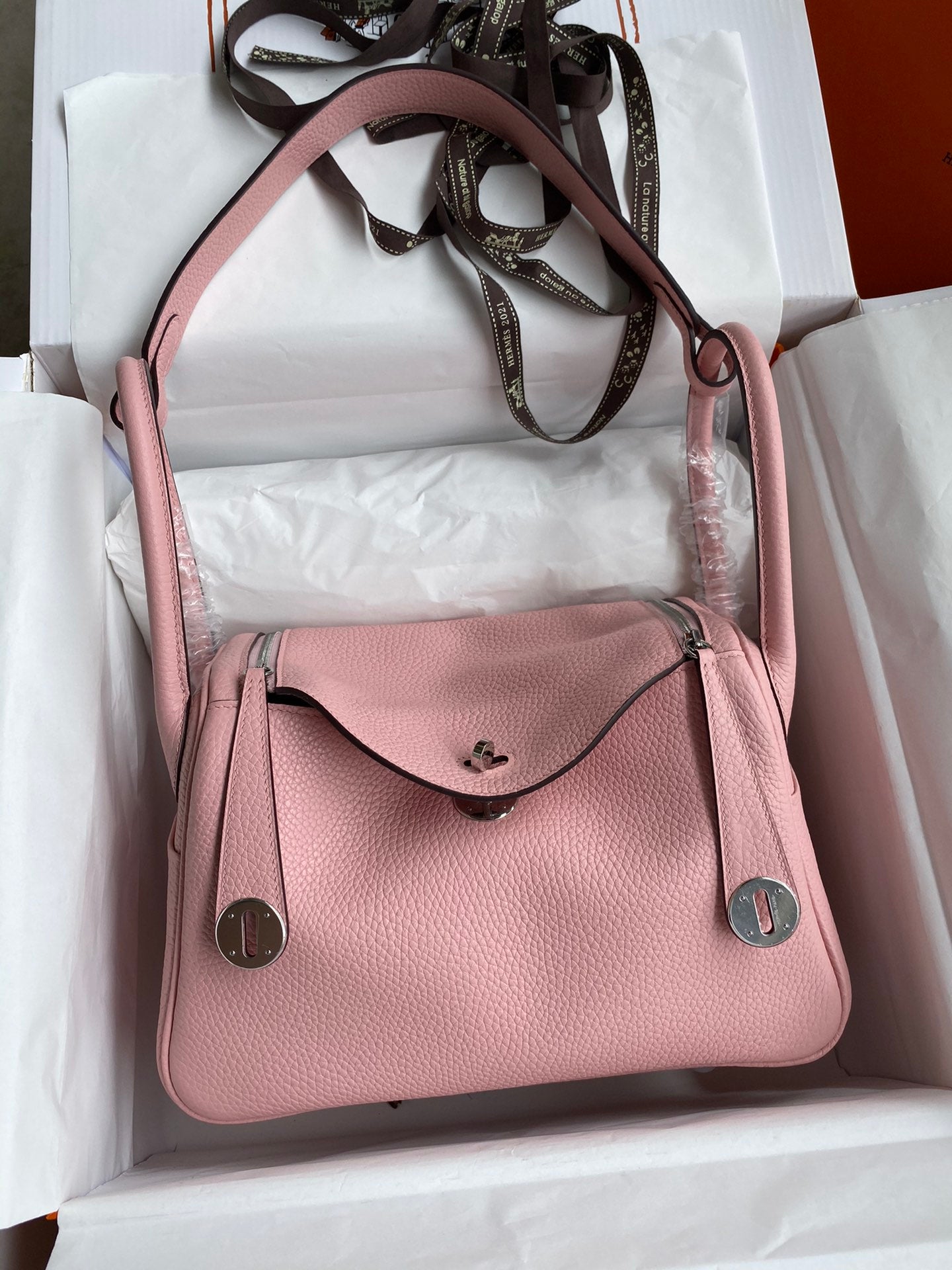 Pink handbag with a visible brand logo in an open box