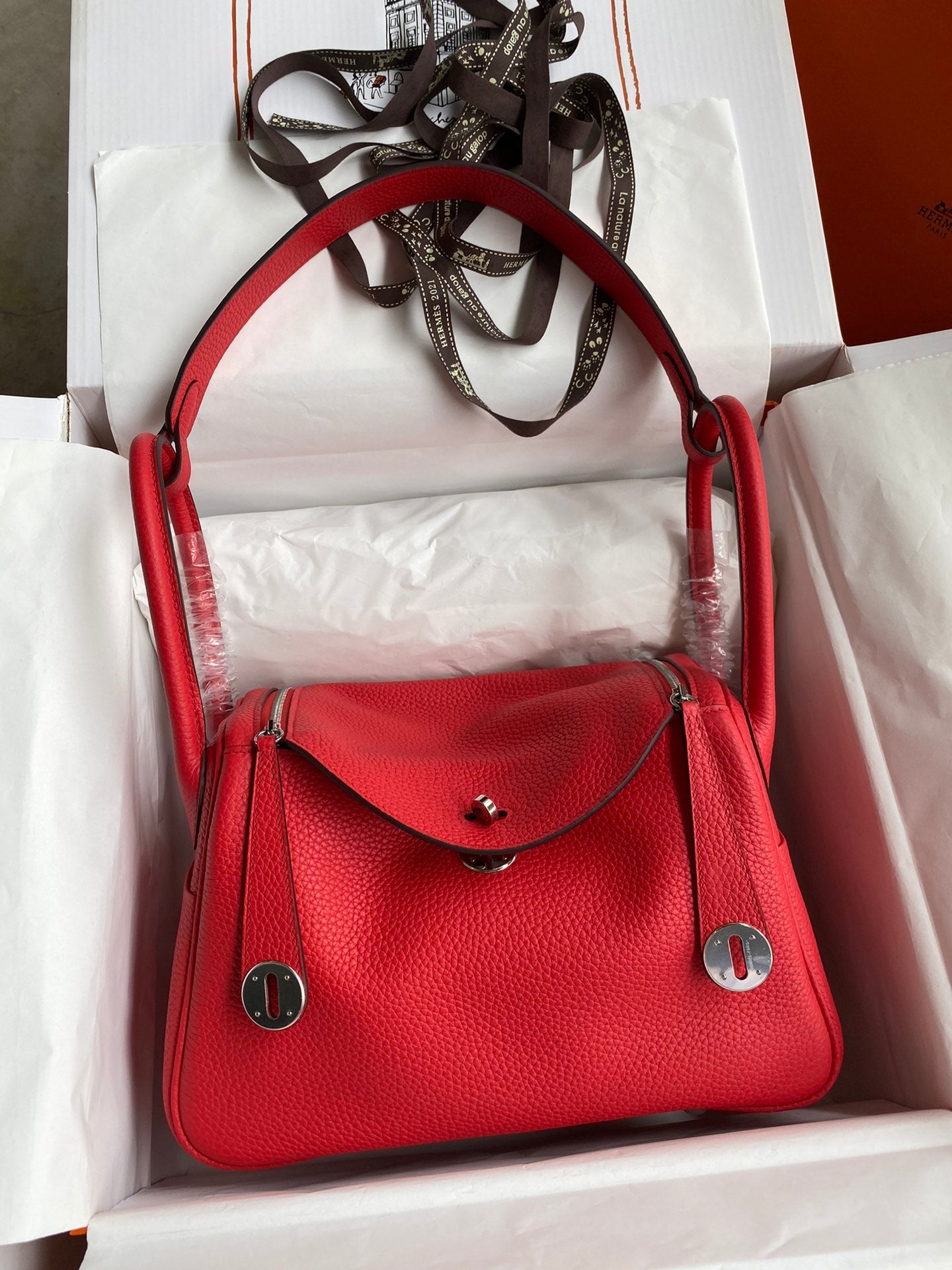Red handbag with silver accents in a box