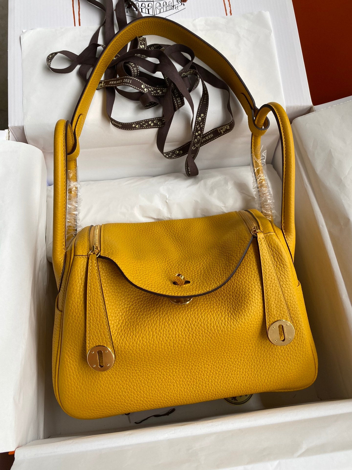 Yellow handbag with gold accents in a box